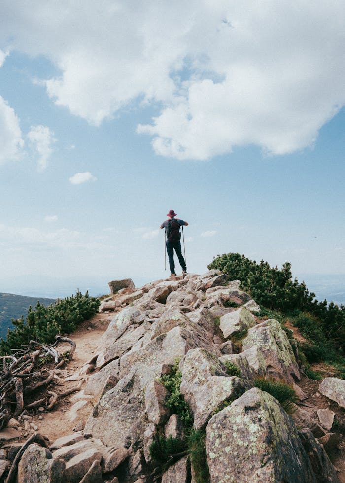 Man hiking on rocky mountain trail in Zakopane, enjoying outdoor adventure and stunning summer views.